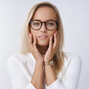 blonde woman touching her glasses