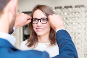 woman trying on glasses in optical shop