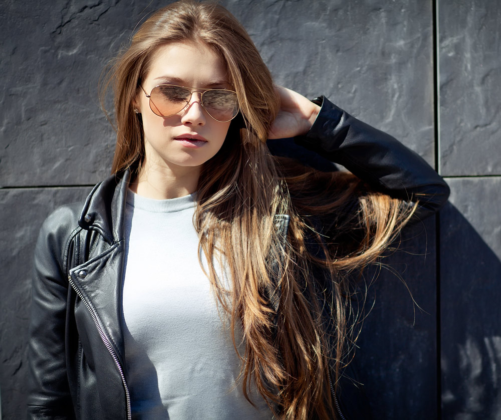 attractive young woman wearing sunglasses in sunlight